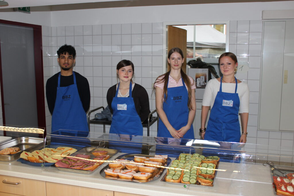 IMG_2116 Drei Schülerinnen und ein Schüler des BBZ zeigen, die belegten Brötchen, die sie für die Gäste fertig gemacht haben