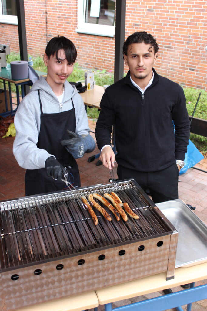 IMG_2157 Zwei Schüler grillen Würstchen für alle Gäste