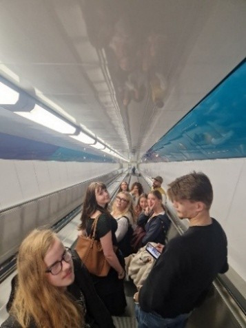 Gruppe auf langer Rolltreppe des Fußgängertunnels